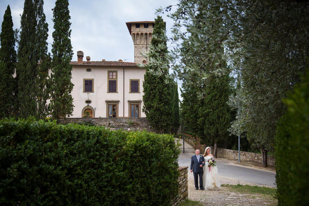 Bride walks towards the church with her father