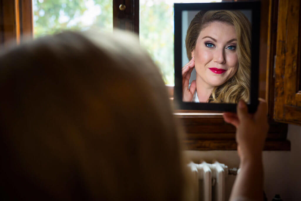 Bride look herself through the mirror