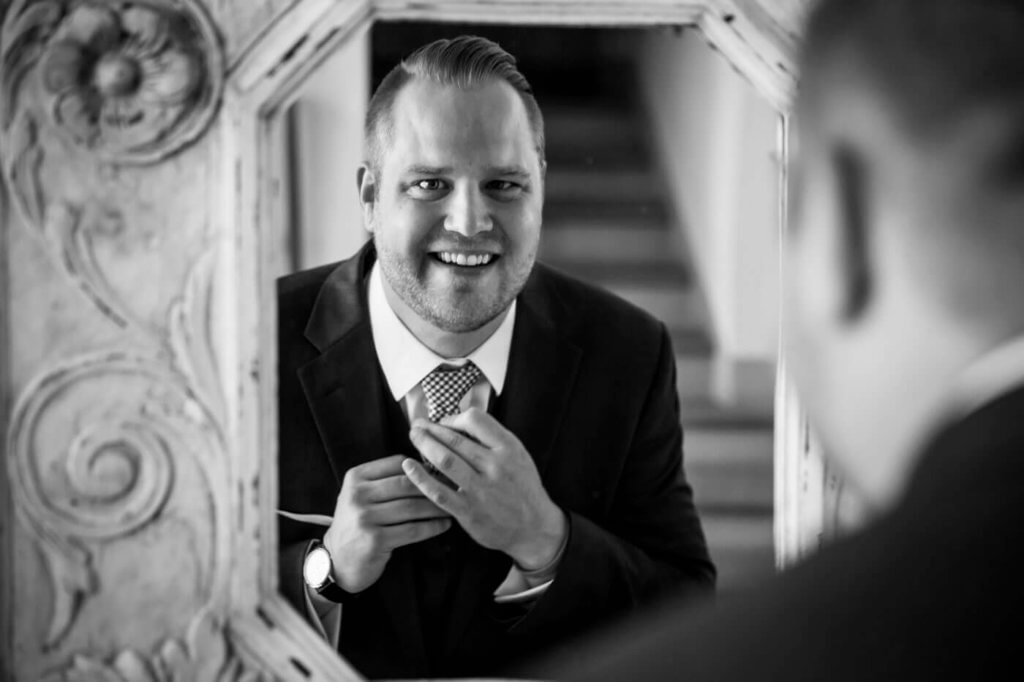 Groom look himself through the mirror