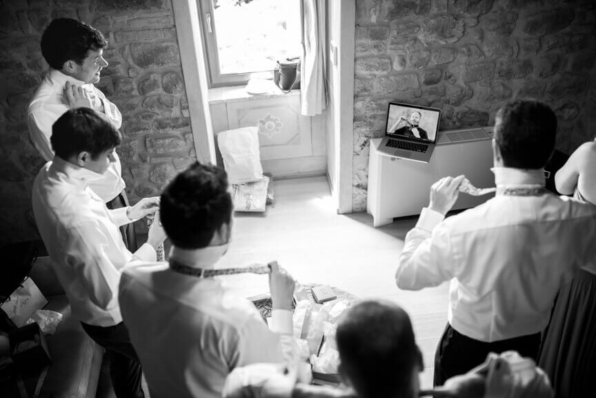 The groom and witnesses learn how to knit the tie