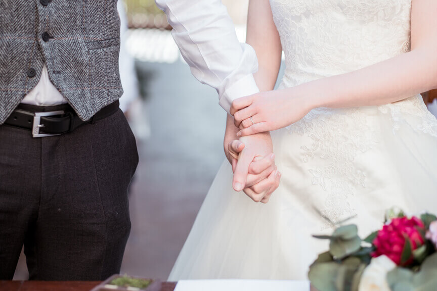 The groom and the bride shake hands during the ceremony