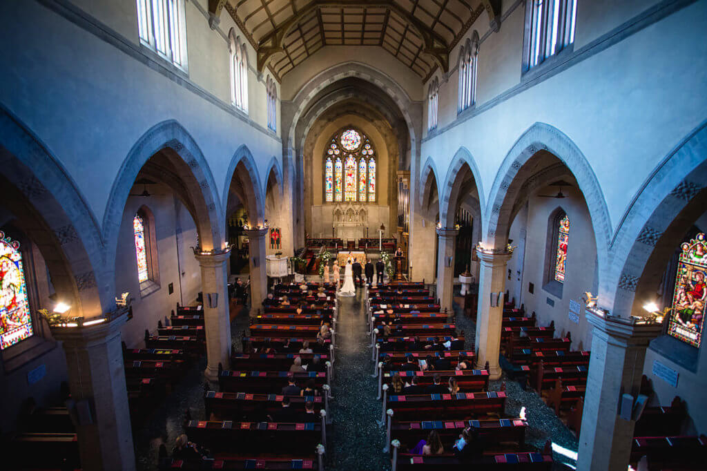 Bride and groom listen to the ceremony in the church