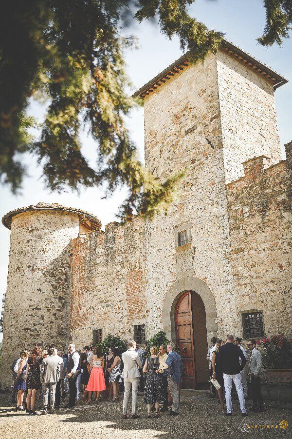 Guests await the bride and groom outside the castle