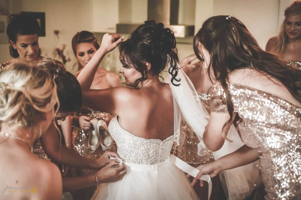 The bride prepares for the ceremony with her bridesmaids