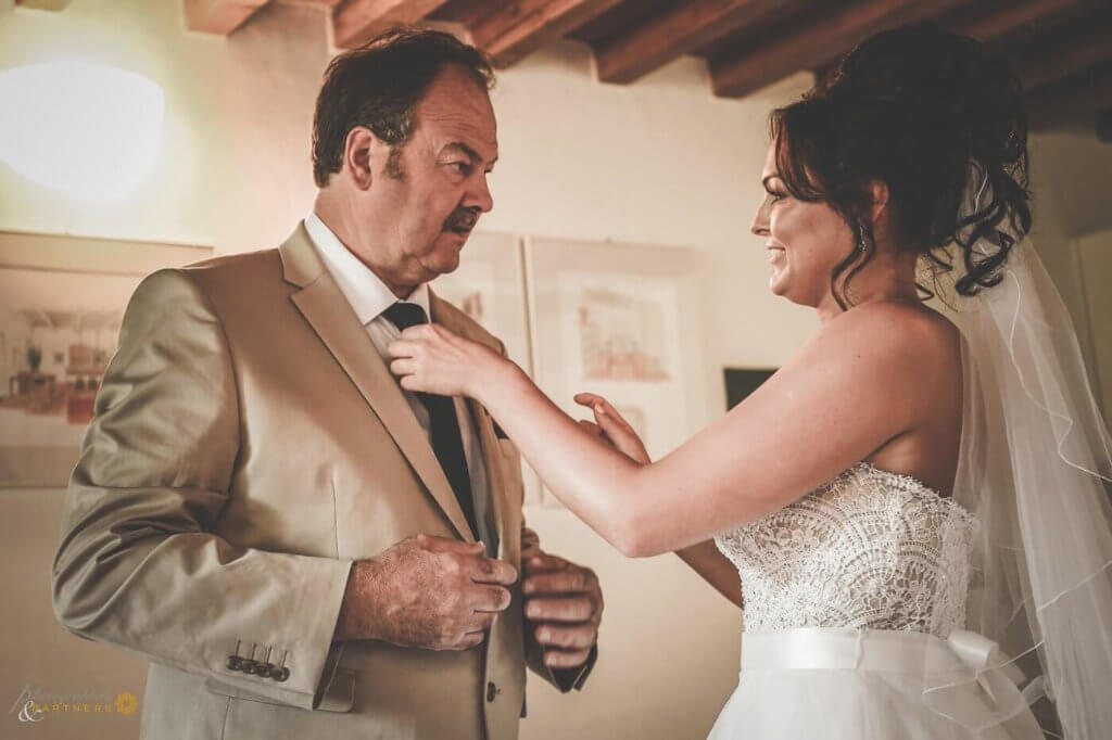 The bride fix up the tie to her father 