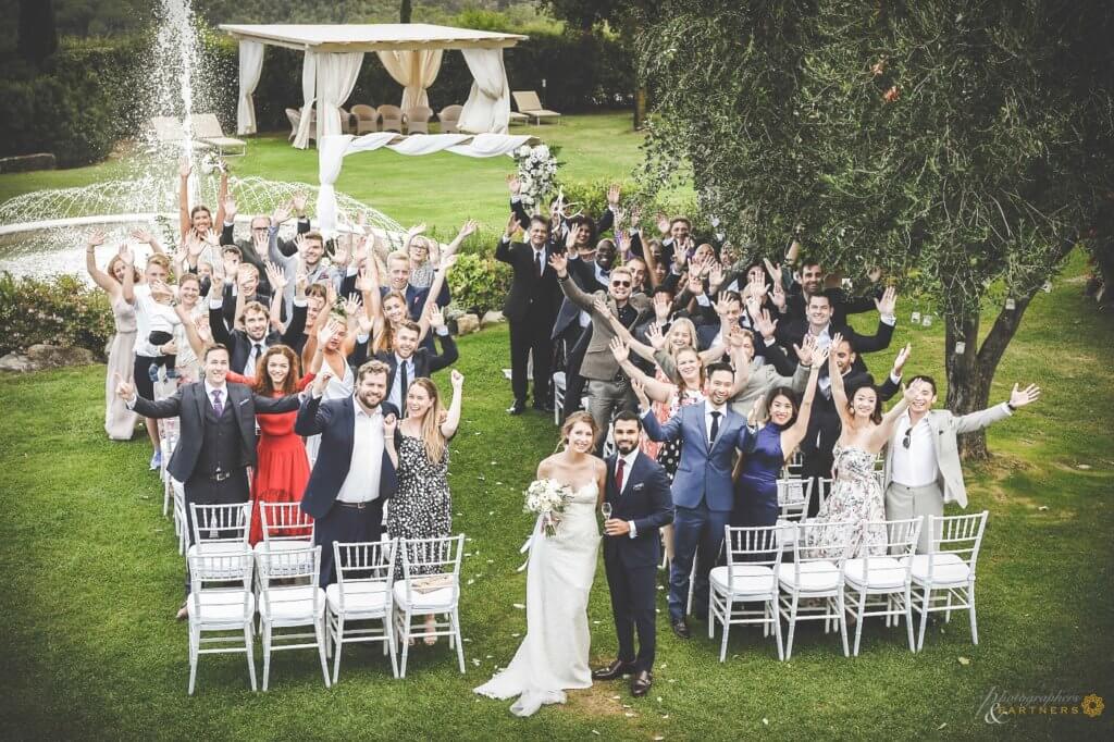 The newlyweds make a photo with their guests after the ceremony