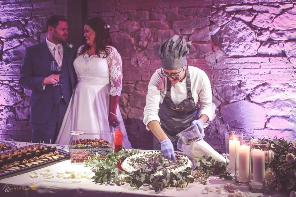 A pastry chef prepares the wedding cake