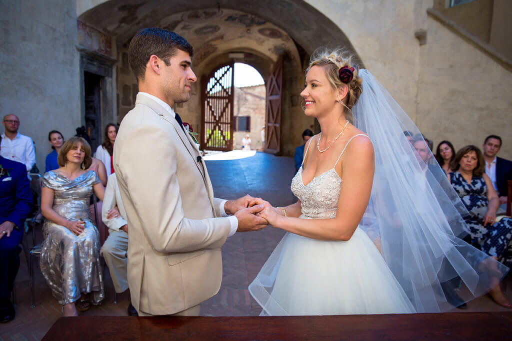 Bride and groom hold hands at wedding ceremony