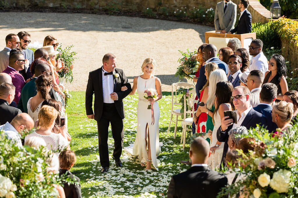 The bride arrives to the location of the ceremony with her father