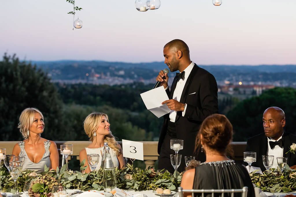 The groom reads a speech for the bride during the dinner