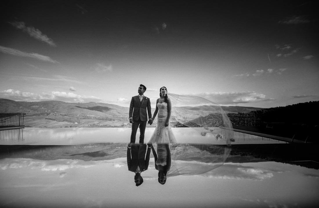 Jane & Aimun hold their hands in front of the pool