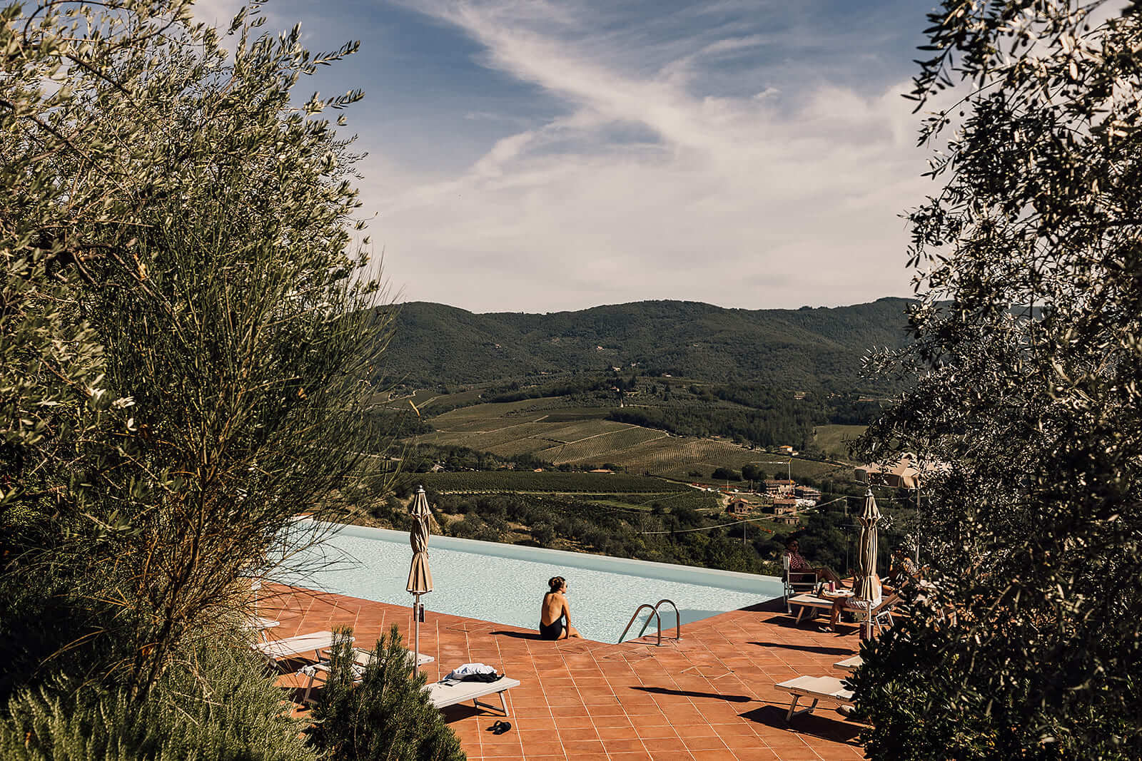 The bride enjoys the swimming pool before the wedding with a wonderful view on tuscan countryside